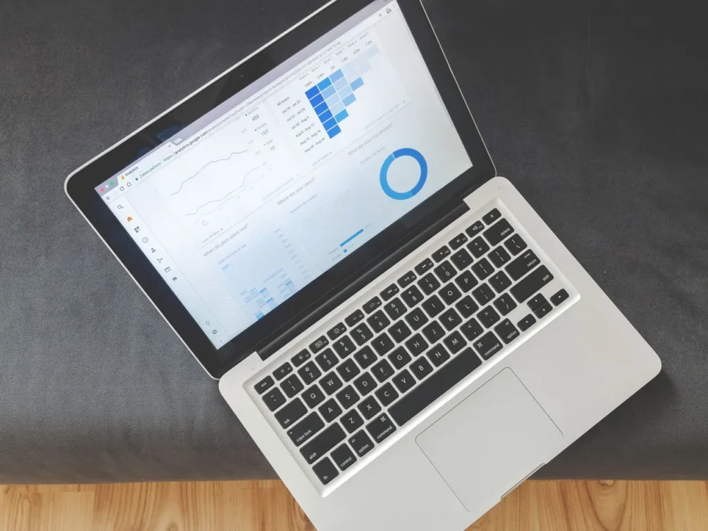 Laptop z widokiem z góry pokazujący wykresy i dane analityczne SEO