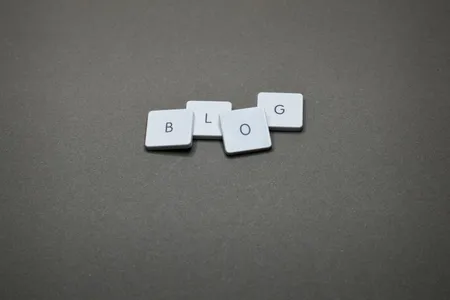 Napis BLOG ułożony z białych klocków na szarym tle