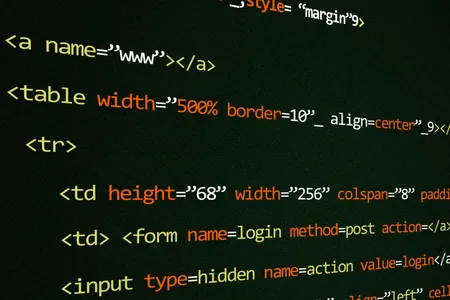 Zbliżenie kodu HTML na ciemnym ekranie komputera