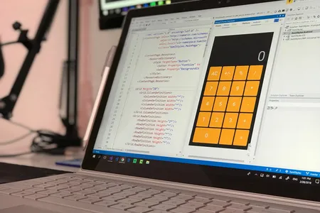 Ekran laptopa z kodem aplikacji i interfejsem kalkulatora