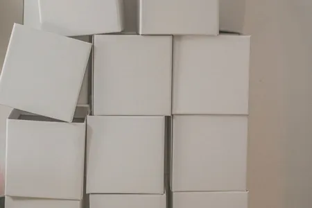Stos białych kartonowych pudełek przygotowanych do wysyłki